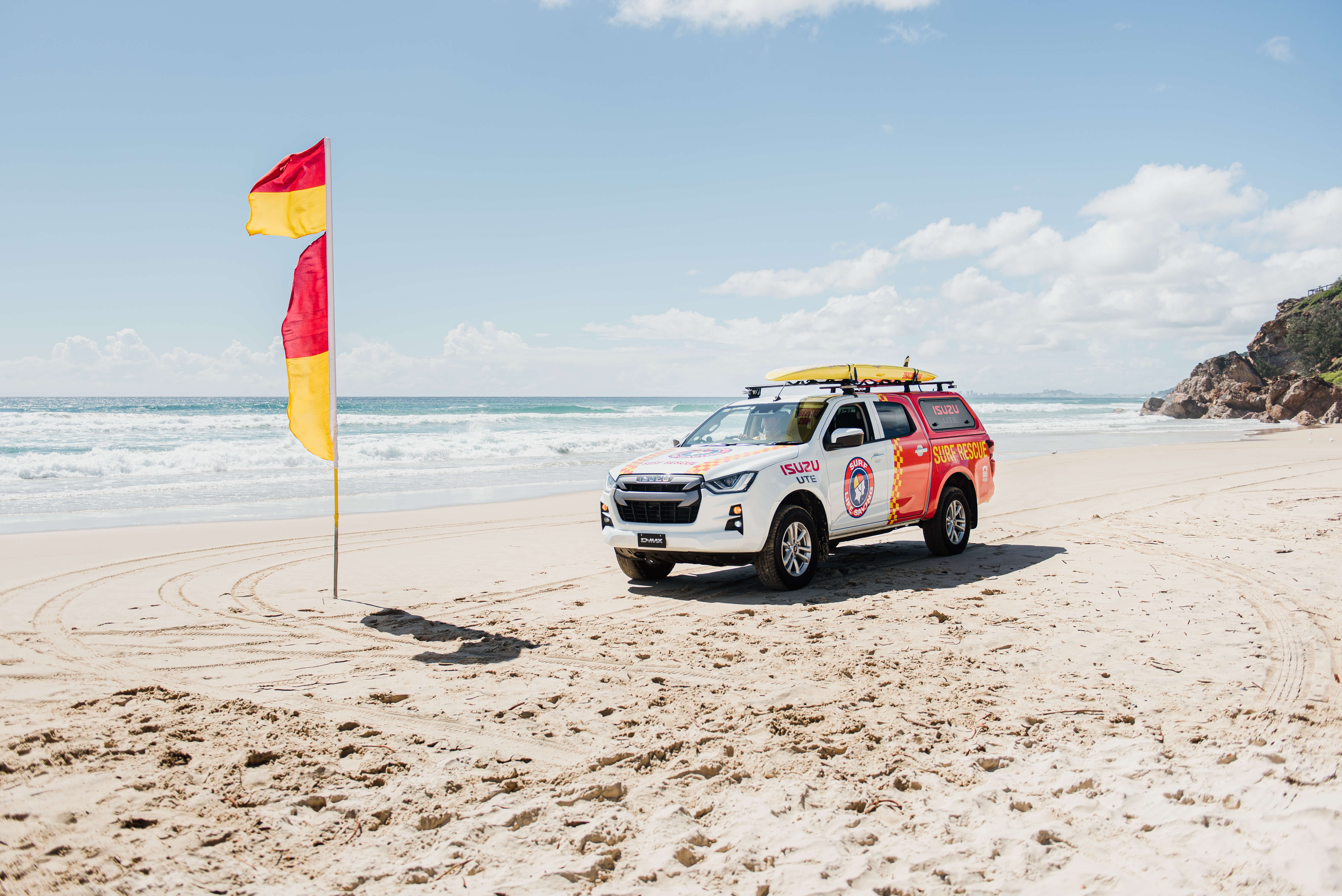 ISUZU Ute in Surf Life Saving colours parked on beach